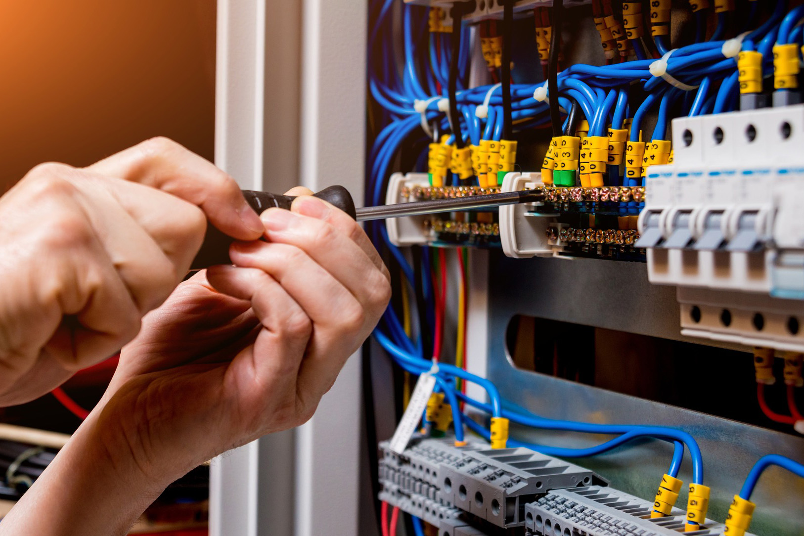Electricians hands, using screwdriver to repair fuse box - Springfield, IL