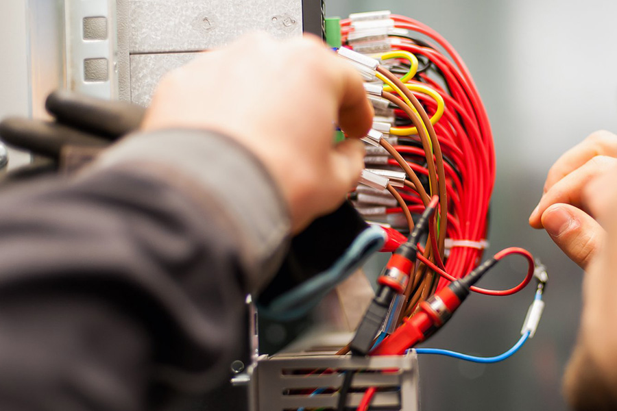 Electrician's hands arranging wiring in fuse box - Springfield, IL