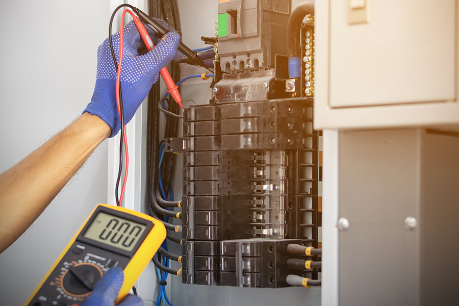 Electrician's hands doing maintenance on residential fuse box - Springfield, IL